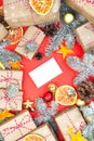 Postcard mockup with many presents and christmas decor on red background. Greetings zero waste template Royalty Free Stock Photo