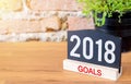 New year 2018 goals on blackboard sign and green plant on wood t Royalty Free Stock Photo