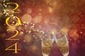 new year 2024, gold text on red background and out-of-focus lights, with toast with champagne flutes Royalty Free Stock Photo