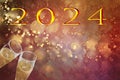new year 2024, gold text on red background and out-of-focus lights, with toast with champagne flutes Royalty Free Stock Photo