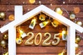 New Year 2025 golden letters under roof house. Calendar, greeting card. Purchase, construction, relocation, mortgage,