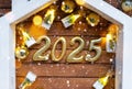 New Year 2025 golden letters under roof house. Calendar, greeting card. Purchase, construction, relocation, mortgage,