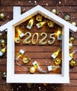 New Year 2025 golden letters under roof house. Calendar, greeting card. Purchase, construction, relocation, mortgage,