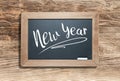 New Year Written on Slate Chalk Board Against Aged Wood Background Royalty Free Stock Photo