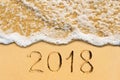 New Year 2018 handwritten on the sandy beach