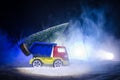 Miniature car with fir tree on Snowy Winter Fores, or toy car carrying a christmas tree and at night time Royalty Free Stock Photo