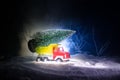Miniature car with fir tree on Snowy Winter Fores, or toy car carrying a christmas tree and at night time Royalty Free Stock Photo