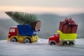 New Year holiday concept. Miniature car with fir tree on Snowy Winter Forest, or toy car carrying a Christmas tree and at snowy ro Royalty Free Stock Photo