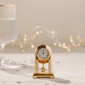 New Year holiday party celebration time. Vintage gold clock showing twelve o'clock, midnight, on beige linen Royalty Free Stock Photo