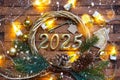 New Year House key with keychain cottage on festive brown wooden background with number 2025 in wreath, lights of garlands.