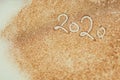 2020 New Year inscription. Golden glitter background texture. Christmas theme. New Year celebration. Confetti on the table.