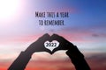New year inspirational motivational quote - Make this a year to remember. Silhouette of a person holding a heart shaped hands.