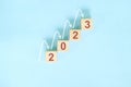 New year 2023 ladder of success, positive outlook and step by step or gradual growth concept. Wooden block.