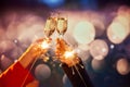 New Year. Male and female hands clinking champagne glasses over bokeh background. Making wishes, celebrating magic