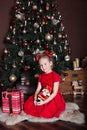 New Year 2020. Merry Christmas, happy holidays. Cute girl holds a nutcracker toy in hands in front of a Christmas tree and gifts. Royalty Free Stock Photo