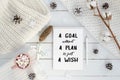 New year motivation a goal without a plan is just a wish. Christmas decorations, knitted blanket, pine cones,cotton Royalty Free Stock Photo