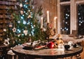 New year night table decoration with candles and antique decorations on the background of lights and Christmas tree Royalty Free Stock Photo