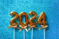 2024 New Year numbers Concept - Orange old gold numbers on light blue glitter background Royalty Free Stock Photo