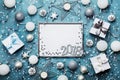 New year 2018 party background. Silver frame with christmas decoration, gift box, confetti and sequins on vintage blue table. Royalty Free Stock Photo