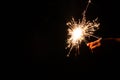 New year party burning sparkler with kids hand on black background. Children hold glowing holiday sparkling hand fireworks Royalty Free Stock Photo