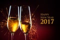 New Year party time with two champagne glasses and sparklers against a dark red background with text Happy New Year 2017 Royalty Free Stock Photo