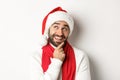 New Year party and winter holidays concept. Close-up of handsome bearded man looking thoughtful, planning Christmas gift