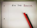 New Year resolution written on a retro style blank sheet of paper in a notebook with pens placed on top as a motivation for Royalty Free Stock Photo