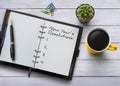 New Year resolutions, goals or action plan concept. Notebook on white wooden table with coffee, plant and stationery. Flat lay Royalty Free Stock Photo