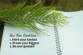 New year resolutions list concept - Work hard. Dream your biggest. Be your greatest. With green palm leaf and text on book. Royalty Free Stock Photo