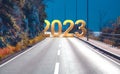 2023 New Year road trip and future vision concept. 2023 with highway road leading forward to happy new year celebration in Royalty Free Stock Photo