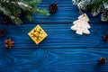 New year`s background. Christmas toys, present, spruce branches, pine cone on blue wooden background top view copyspace Royalty Free Stock Photo