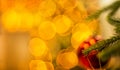 New Year`s ball decoration on the Christmas tree with beautiful luminous yellow blurs with copy space for a text