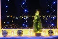 New Year's Christmas tree on the window on background of the night city. Garlands, lights, bokeh. Royalty Free Stock Photo