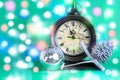 Christmas greeting card. New Year`s clock midnight, bauble and cone. Colorful bokeh holidays background. Royalty Free Stock Photo