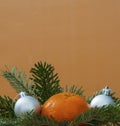 New Year`s composition of Christmas tree branches, tangerine and toy balls. Selective focus. Conceptual image of a Christmas card