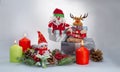 New year`s composition: a toy Santa Claus, a reindeer and a Snowman, burning colored candles and gifts Royalty Free Stock Photo