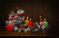 New year`s composition: a toy Santa Claus, a Reindeer and a Snowman, burning colored candles and gifts Royalty Free Stock Photo