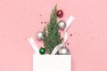 New Year`s composition, winter decoration. Christmas toy balls, holiday ribbons, christmas tree branches white gift bag on pink Royalty Free Stock Photo