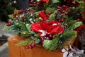 New Year`s decor in a basket of green coniferous branches, red leaves and berries under white snow on the table Royalty Free Stock Photo