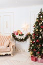 New Year`s decor in the room with a Christmas tree, a fireplace and gifts