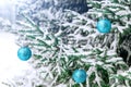 New Year`s decoration balls on a snowy branch. Christmas tree toy on the branches of spruce covered with snow. Blue shiny balloon Royalty Free Stock Photo