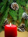 New Year\'s decorations. Pine cone, candle and fir branches on a beige background.