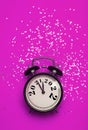 New Year's Eve background concept. 2021 changes to 2022 on an alarm clock on a pink background with festive glitter on Royalty Free Stock Photo