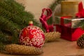 New Year`s eve with a red Christmas ball, cones, spruce branches, Christmas tree toy and gift boxes Royalty Free Stock Photo