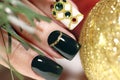 New year`s fashionable beautiful festive manicure on short square nails with green lacquer color.