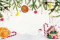 New Year`s festive decor on a white background. Fir branches, decoration of red balls, cones, candies, cookie, house and snowman. Royalty Free Stock Photo