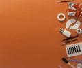 New year`s flatley. Tools for eyelash extension on an orange background, top view. Patches, artificial eyelashes, brushes, glue,