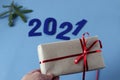 New year`s gift in hand against the background of the figures of the coming year-2021, close - up-the concept of pleasant new yea Royalty Free Stock Photo