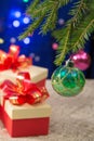 New Year`s gifts next to the decorated Christmas tree on a dark blue background with blurred lights. vertical Royalty Free Stock Photo