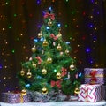 New Year`s gifts under a beautifully decorated Christmas tree against the background of bright bulbs Royalty Free Stock Photo